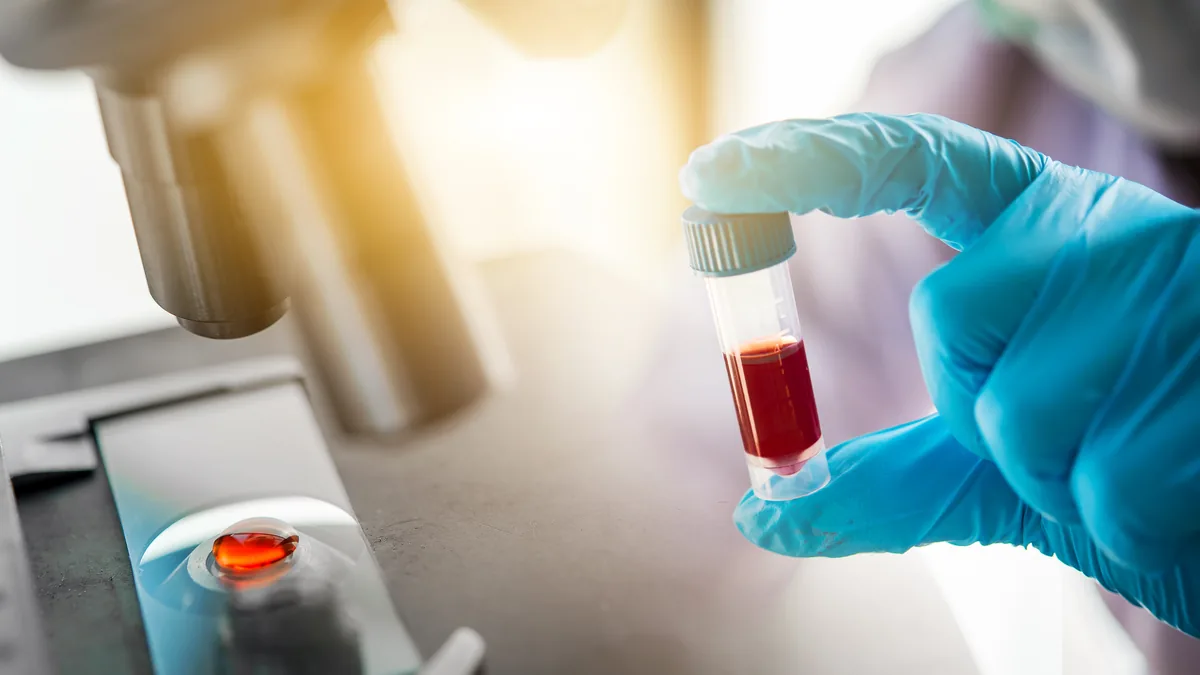 A lab technician handling a blood sample tube, the kind of objective measurement grounding studies mostly lack